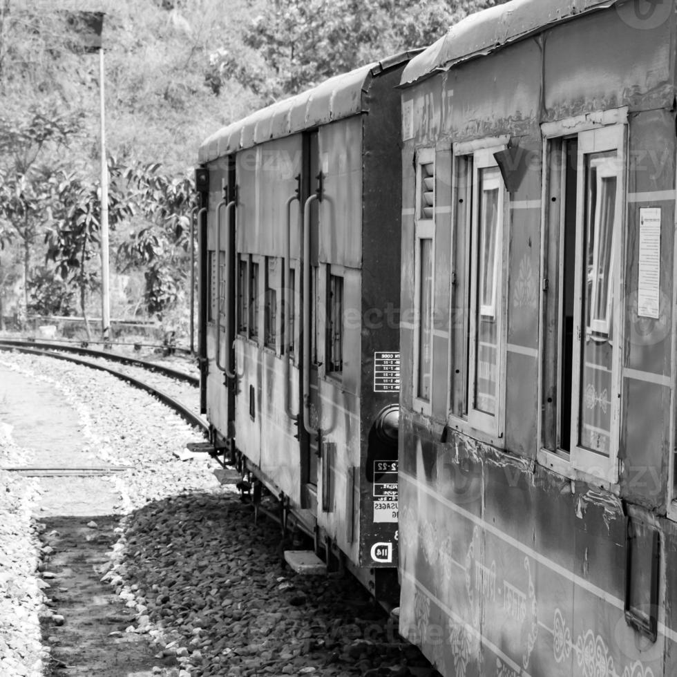 Toy Train moving on mountain slope, beautiful view, 1 side mountain, 1 side valley moving on railway to the hill, among green natural forest. Toy train from Kalka to Shimla in India-Black and White photo