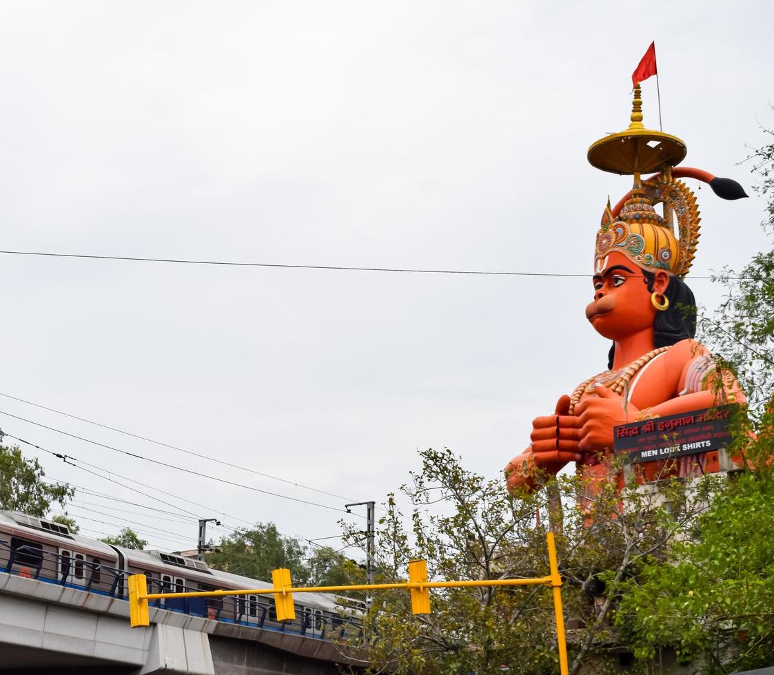 New Delhi, India - June 21, 2022 - Big statue of Lord Hanuman near the delhi metro bridge situated near Karol Bagh, Delhi, India, Lord Hanuman big statue touching sky photo