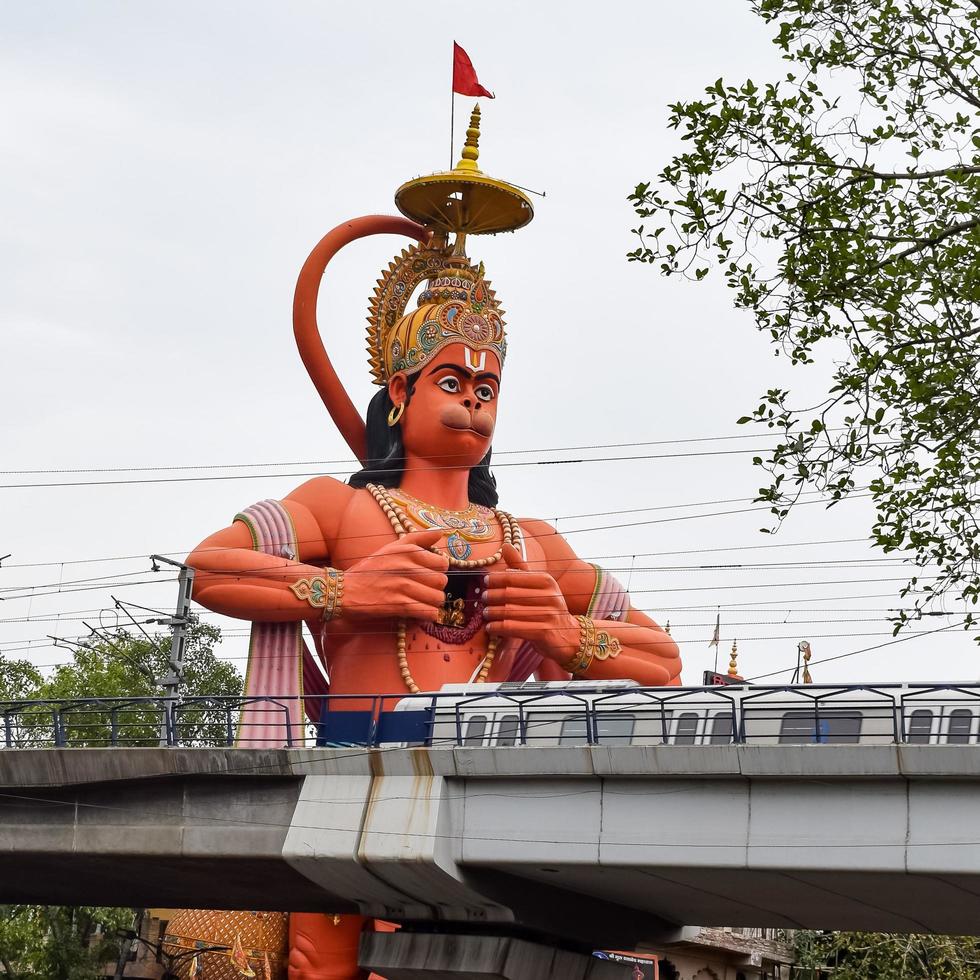 New Delhi, India - June 21, 2022 - Big statue of Lord Hanuman near the delhi metro bridge situated near Karol Bagh, Delhi, India, Lord Hanuman big statue touching sky photo