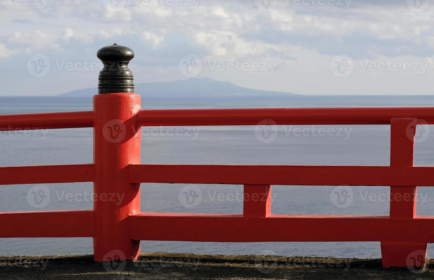 Red fence near the coast with the sea in the background in Enoshima, Japan photo