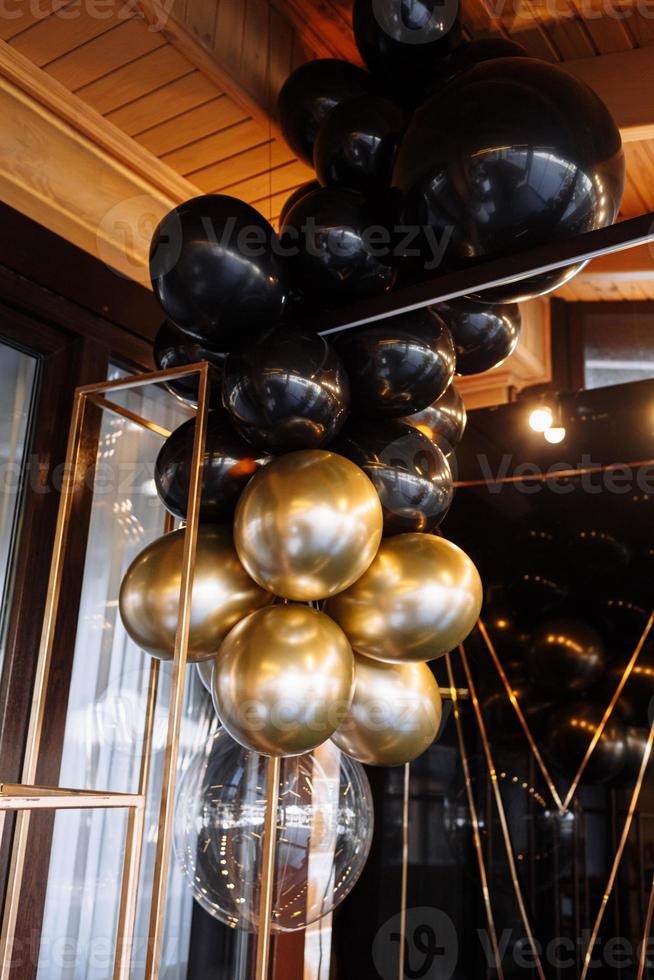 Wedding or birthday photo zone with white, black and gold balloons indoors. Holiday party decoration. Colorful balloons background. Valentines day.