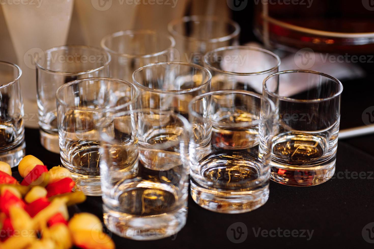 glasses with cognac, whiskey stand on the bar. a lot of glasses with cognac. alcohol in the glasses. Various alcohol drinks standing on bar. glasses with cognac on the bar photo