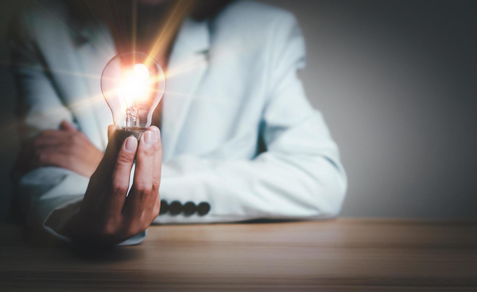 Businesswoman holding a light bulb, Creative new idea. Innovation, brainstorming, solution and inspiration concepts. imagination, creative thinking problem solving. photo