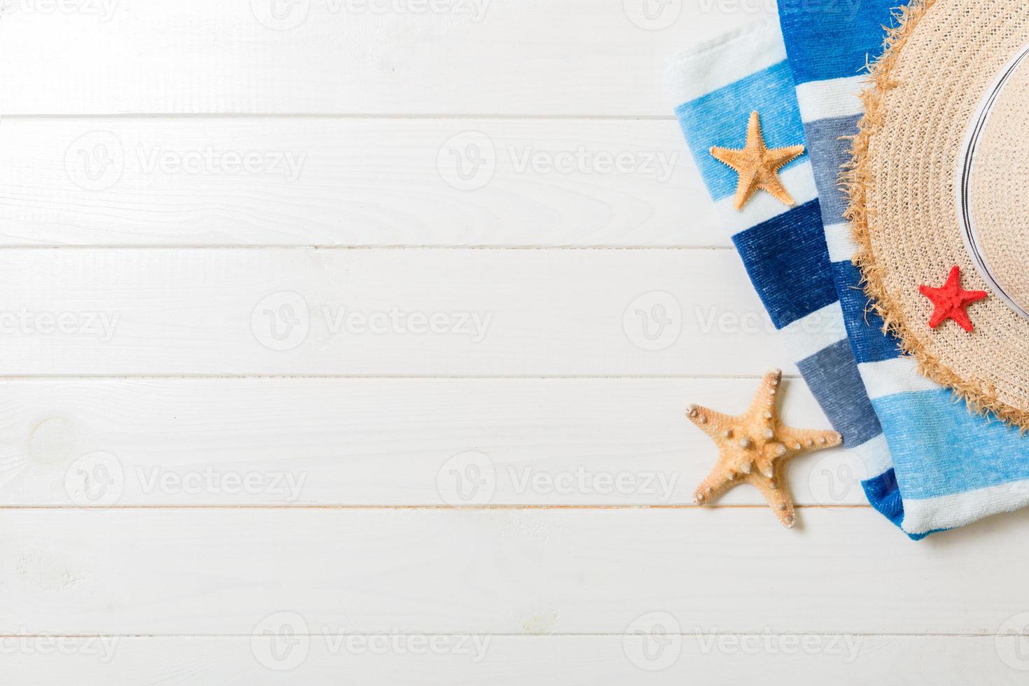Straw hat, blue towel and starfish On a white wooden background. top view summer holiday concept with copy space photo