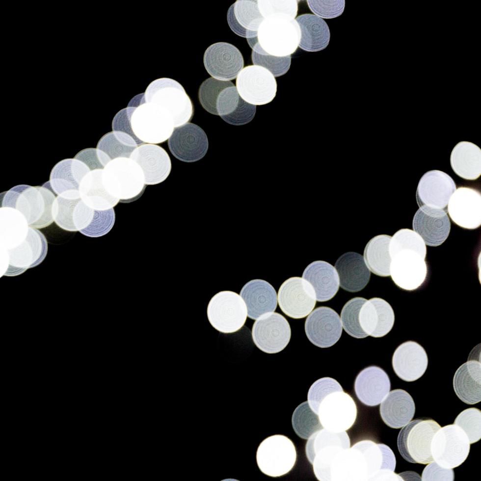 Abstract bokeh of white city lights on black background. defocused and blurred many round light photo