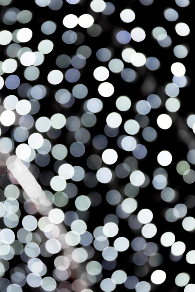 Unfocused abstract white bokeh on black background. defocused and blurred many round light photo