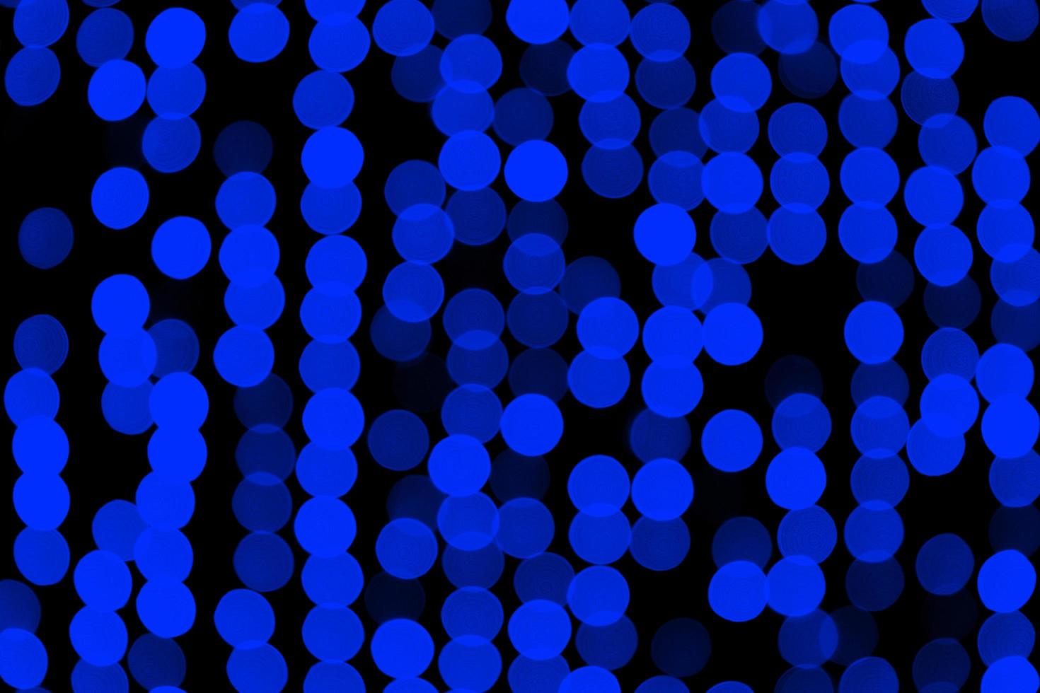 Unfocused abstract dark blue bokeh on black background. defocused and blurred many round light photo