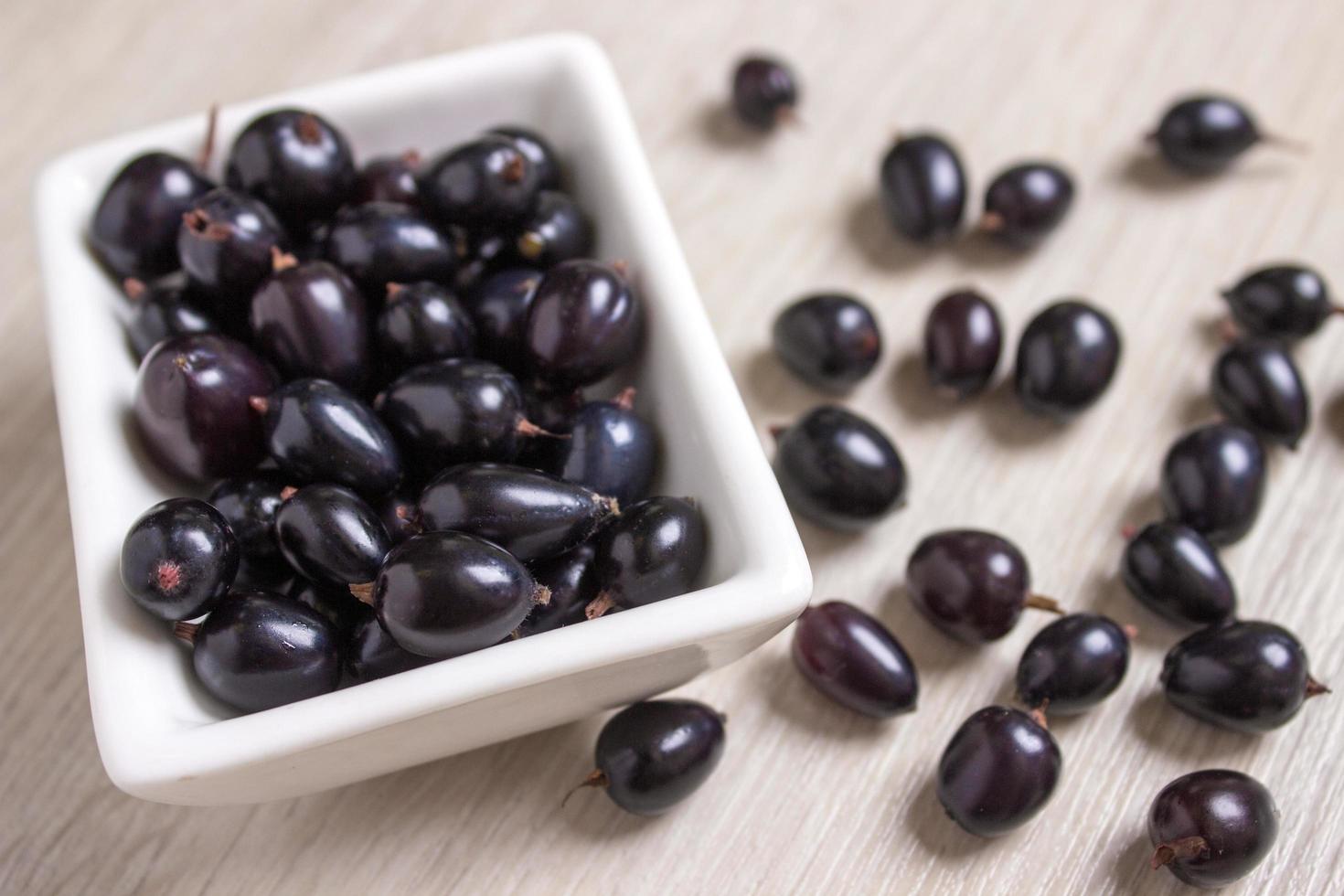 black currant in glassware on white wooden table top view photo