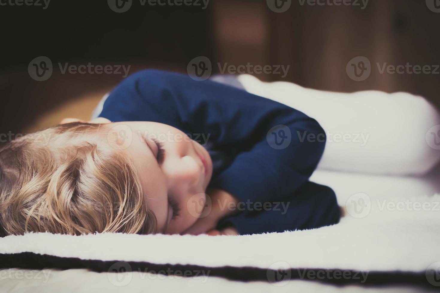 Small boy taking a nap in the bedroom. photo