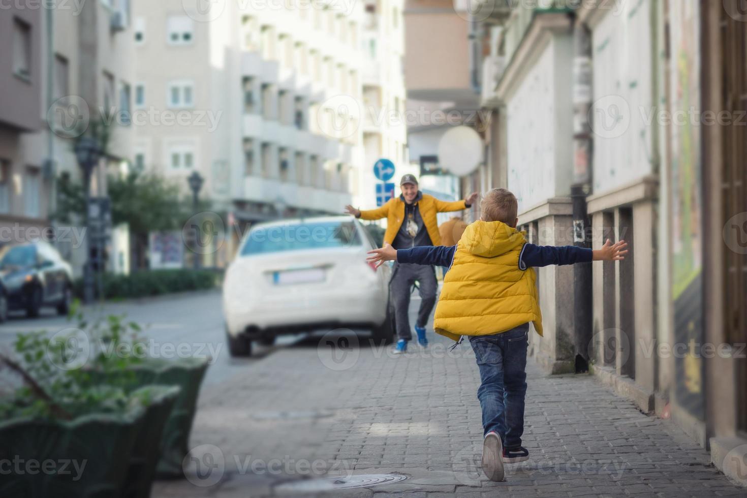 Small boy running into father's arms. photo