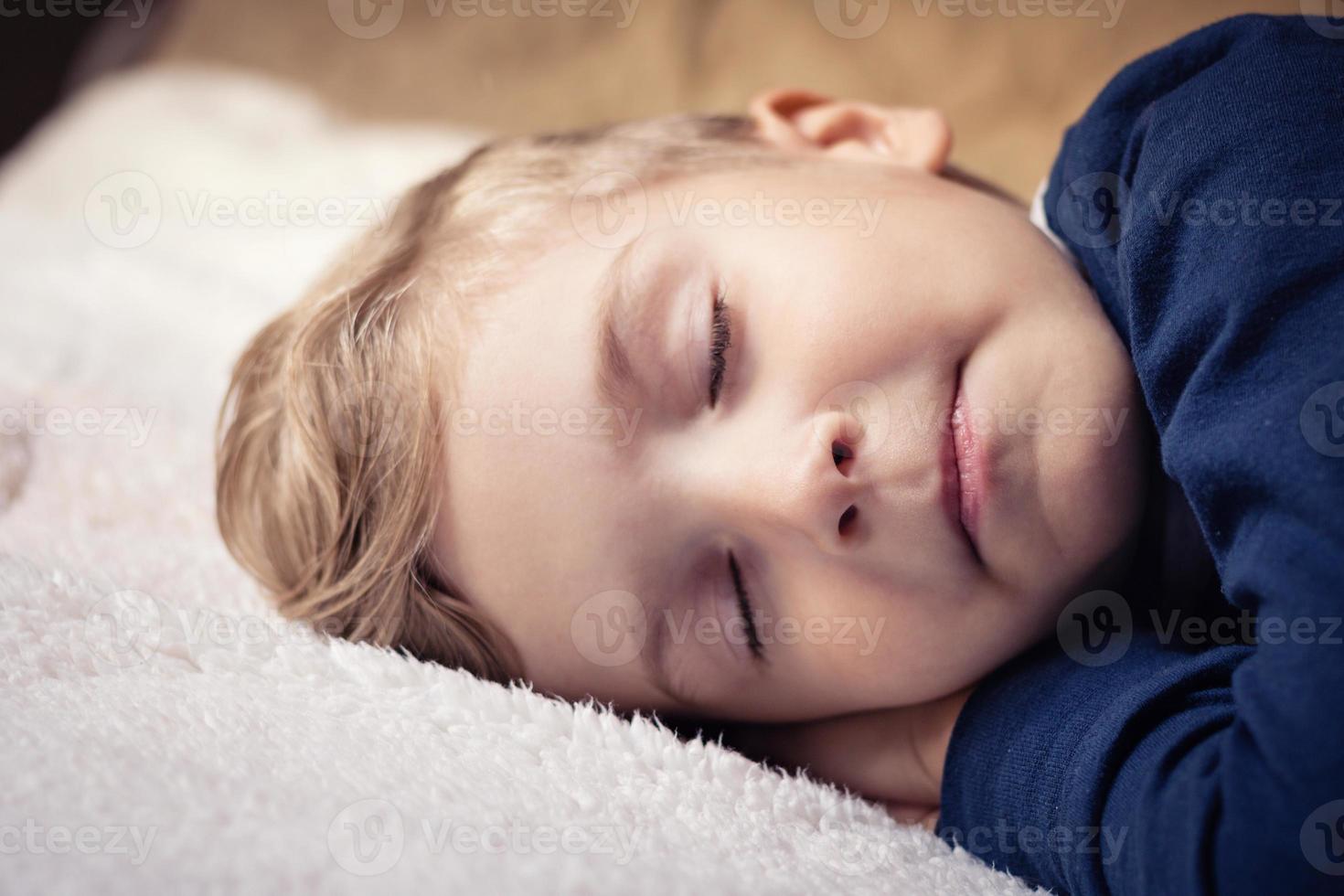 niño dormido en el cama. foto