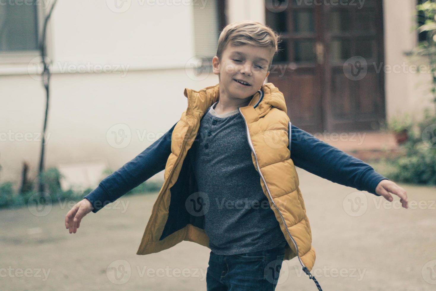 Carefree boy spinning with arms outstretched. photo