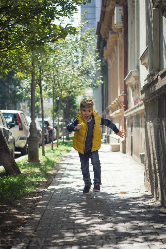 Happy boy running on the street. photo