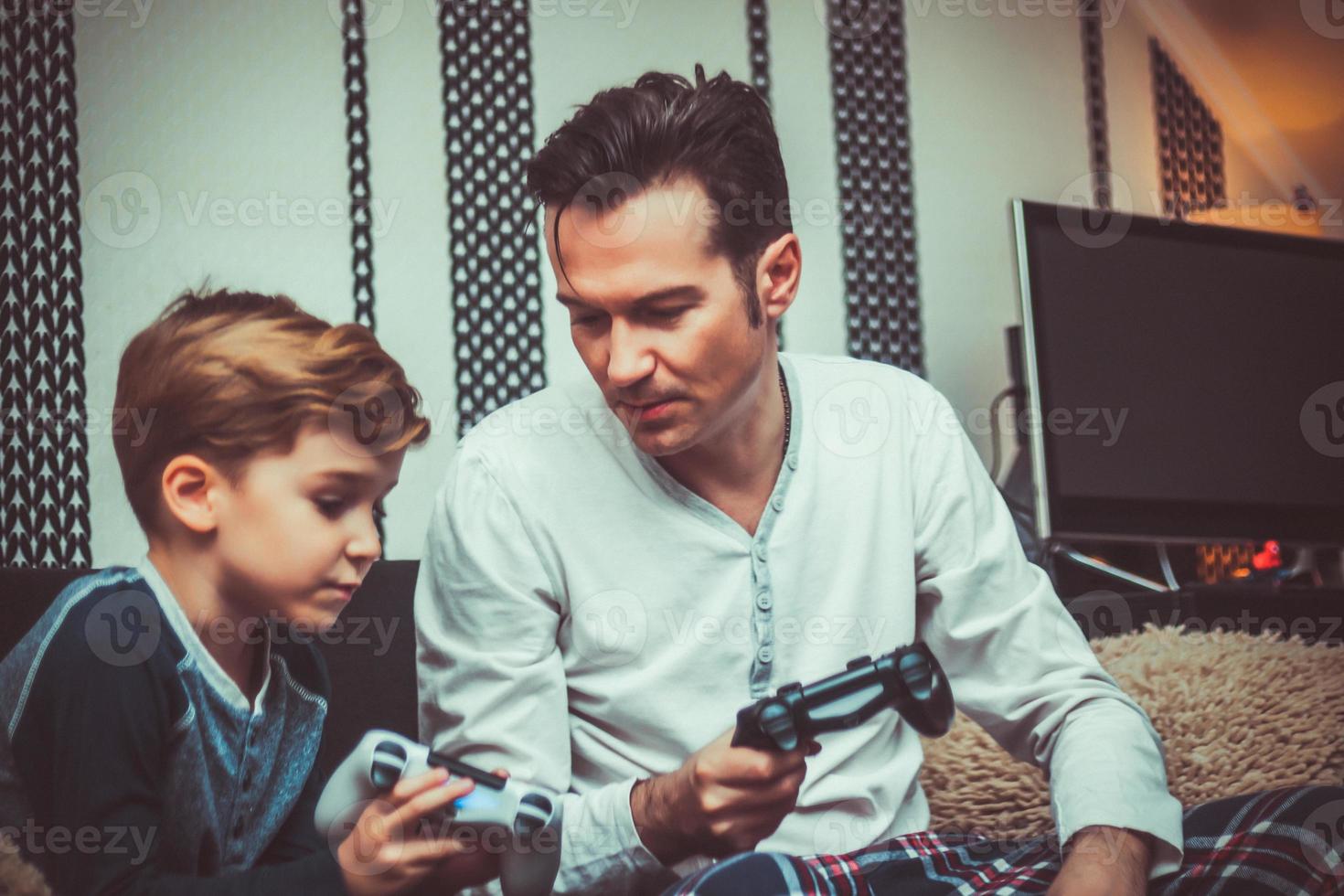 Small boy teaching his father how to use game controller. photo