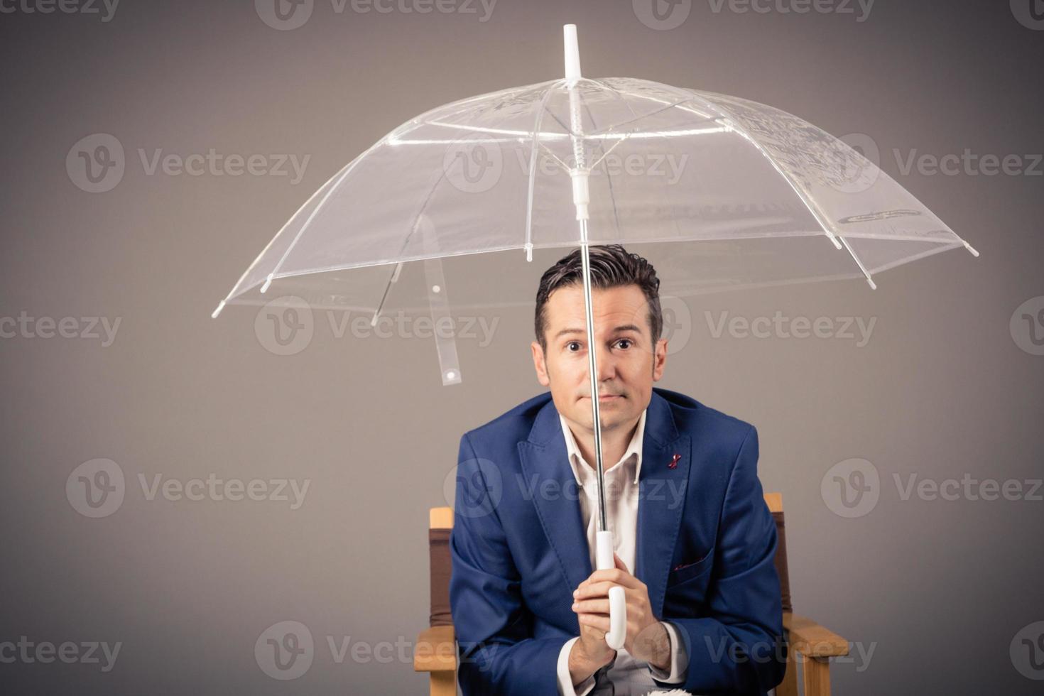 empresario con un paraguas curioso a el cámara. foto