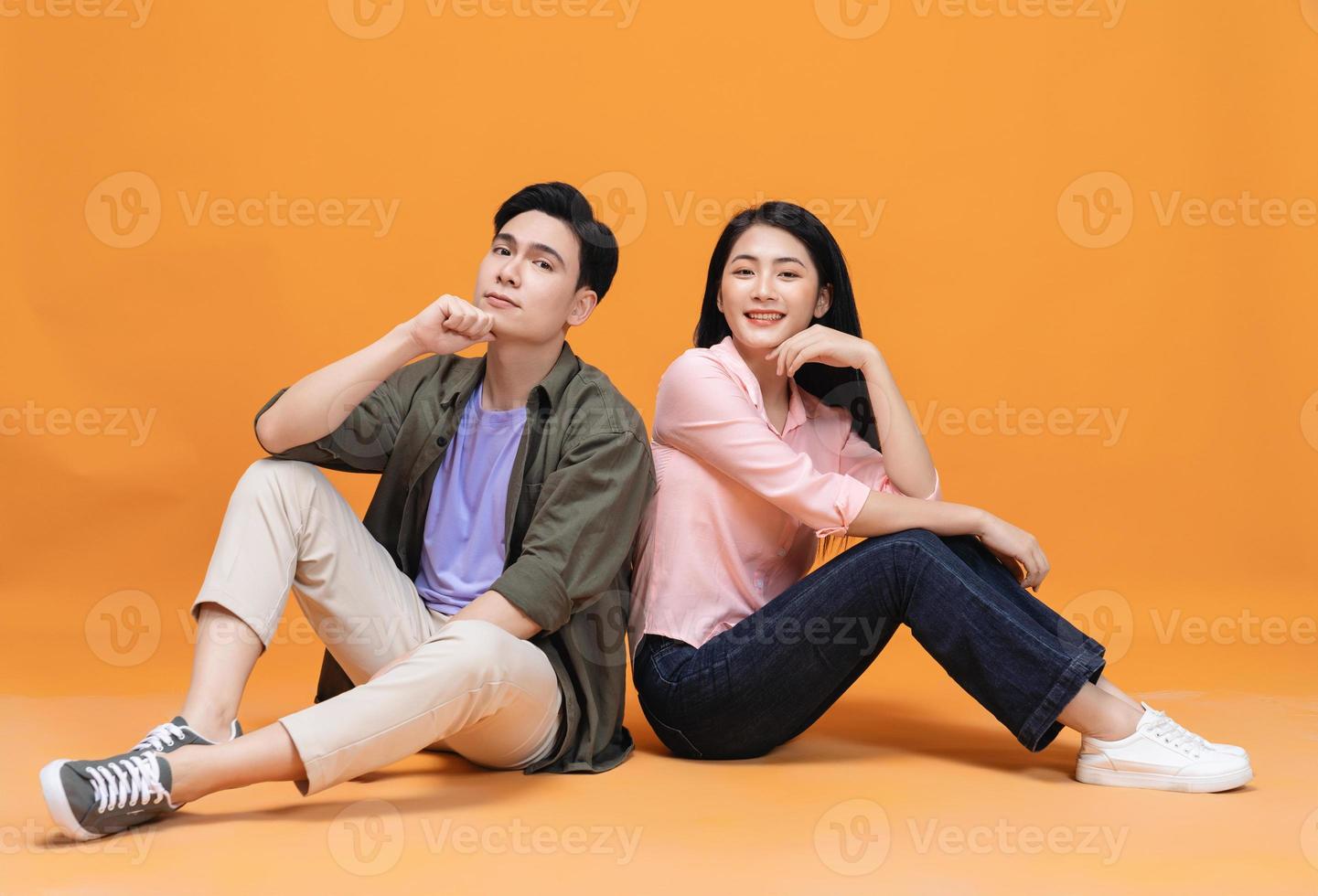 Young Asian couple sitting on background photo