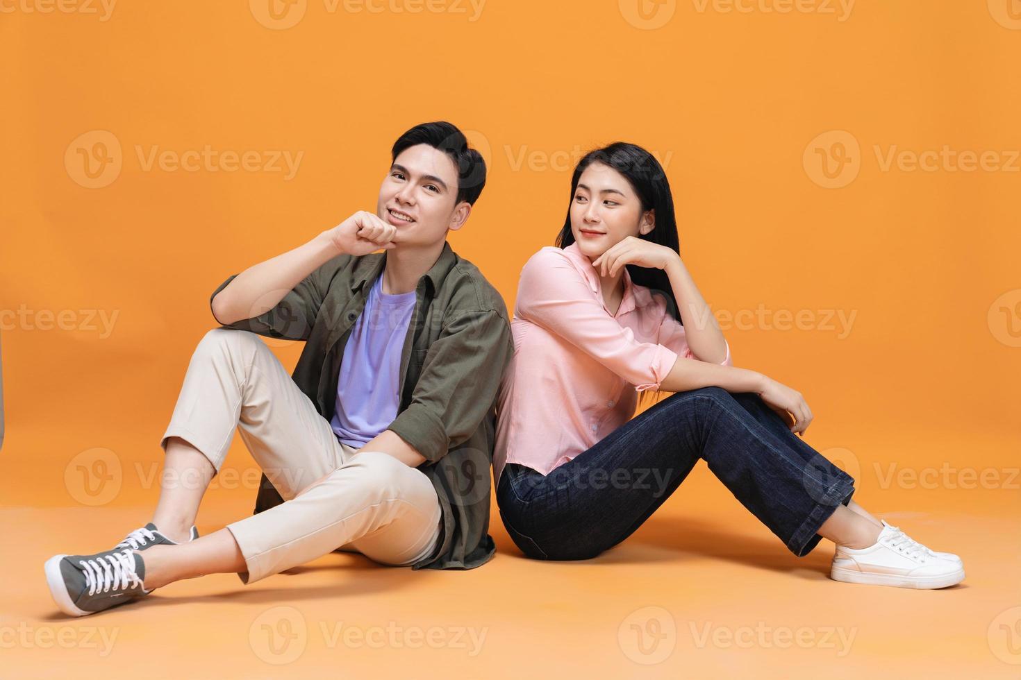 Young Asian couple sitting on background photo