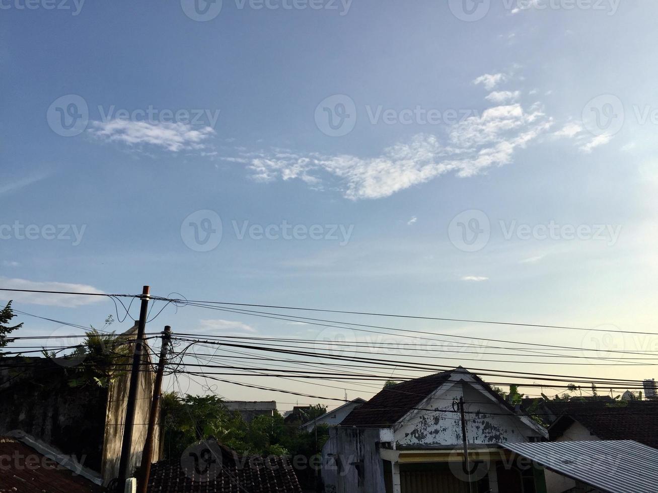 a view of intricate electrical poles and cables around densely populated housing photo