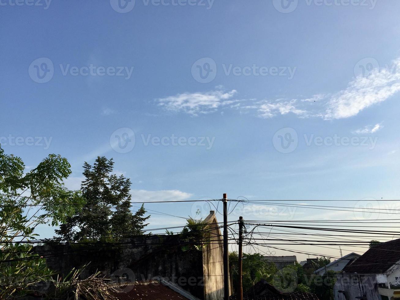 a view of intricate electrical poles and cables around densely populated housing photo