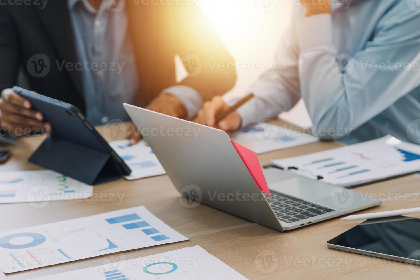 Financial analysts analyze business financial reports on a digital tablet planning investment project during a discussion at a meeting of corporate showing the results of their successful teamwork. photo