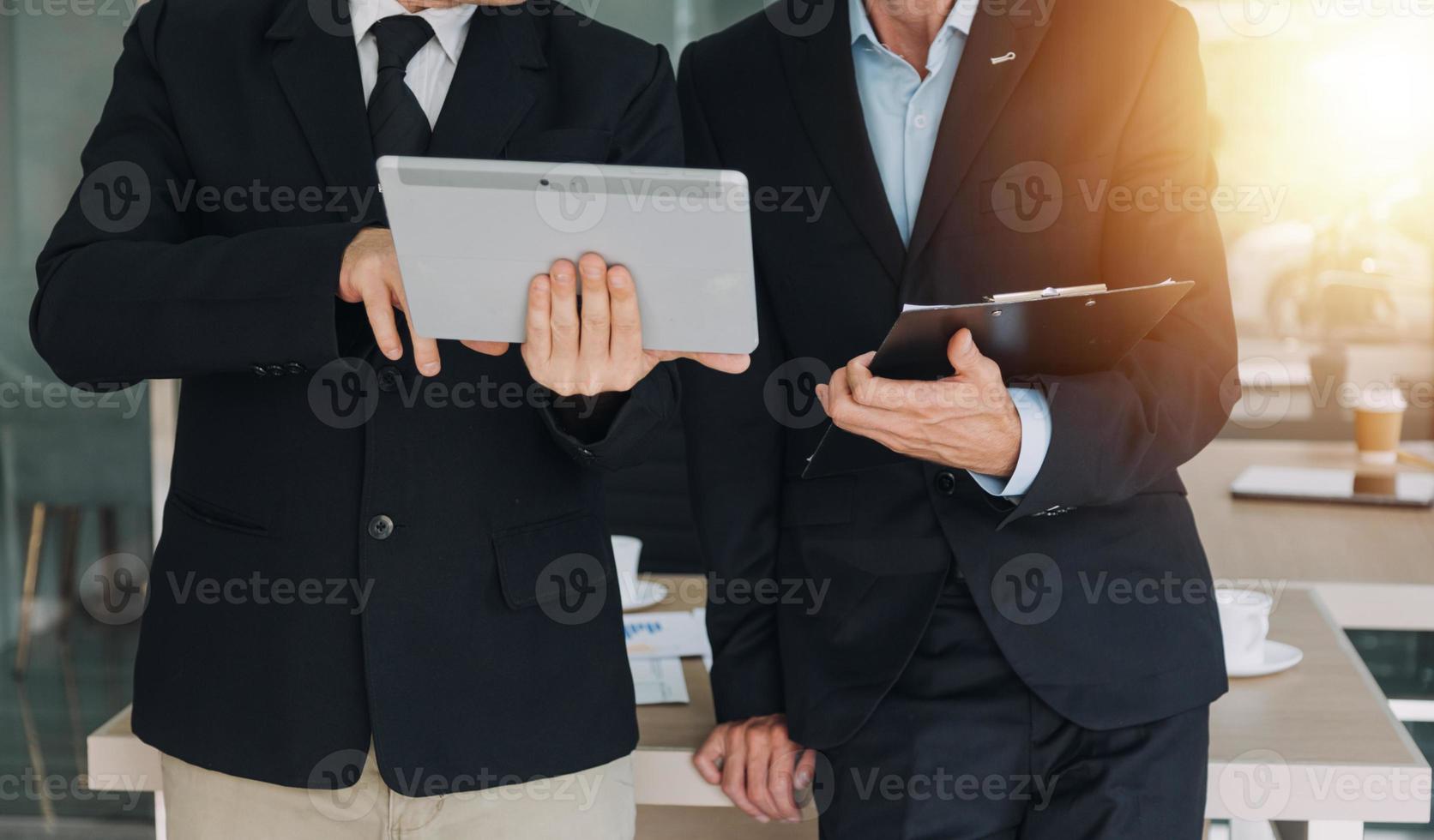 Financial analysts analyze business financial reports on a digital tablet planning investment project during a discussion at a meeting of corporate showing the results of their successful teamwork. photo