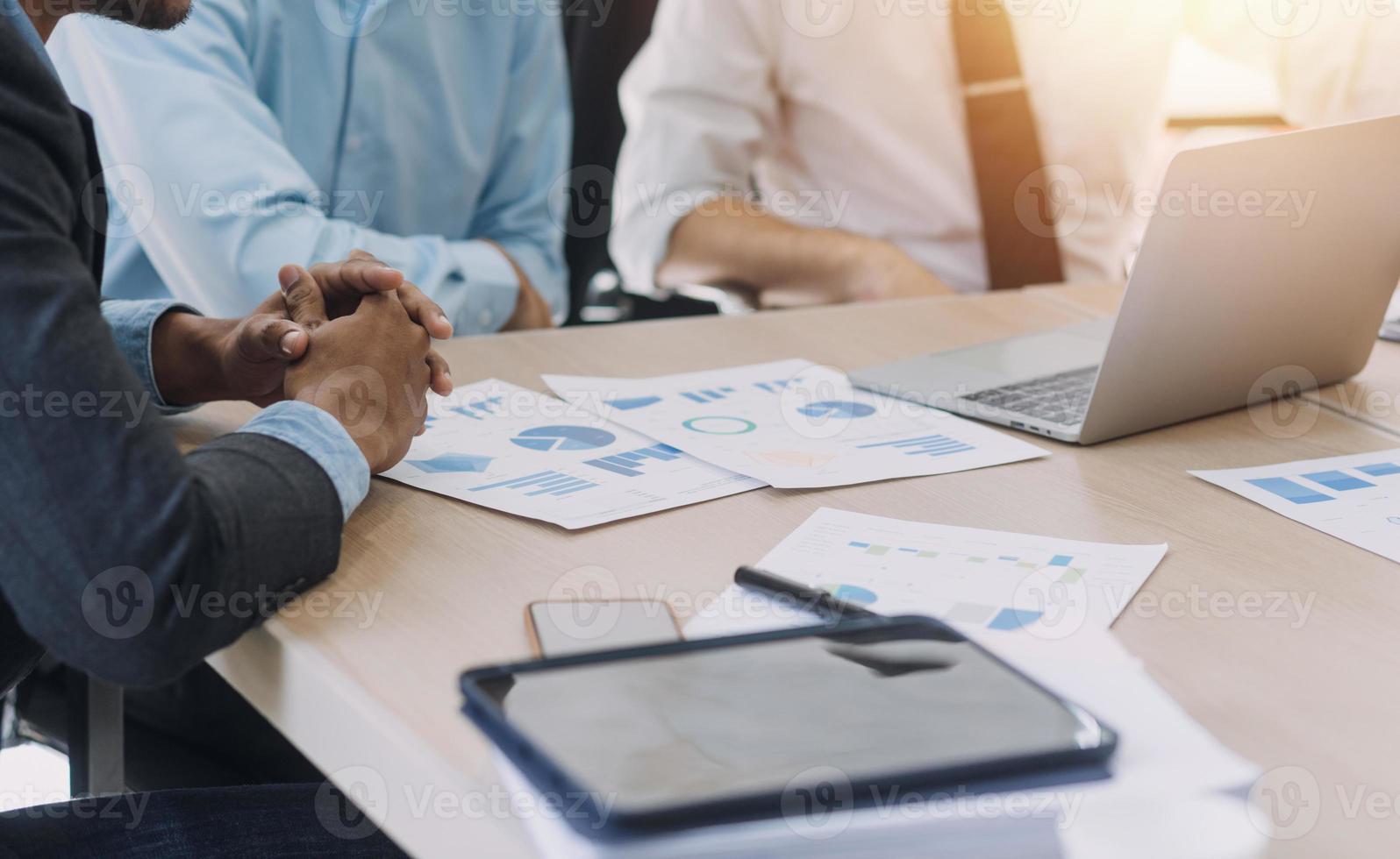 Financial analysts analyze business financial reports on a digital tablet planning investment project during a discussion at a meeting of corporate showing the results of their successful teamwork. photo