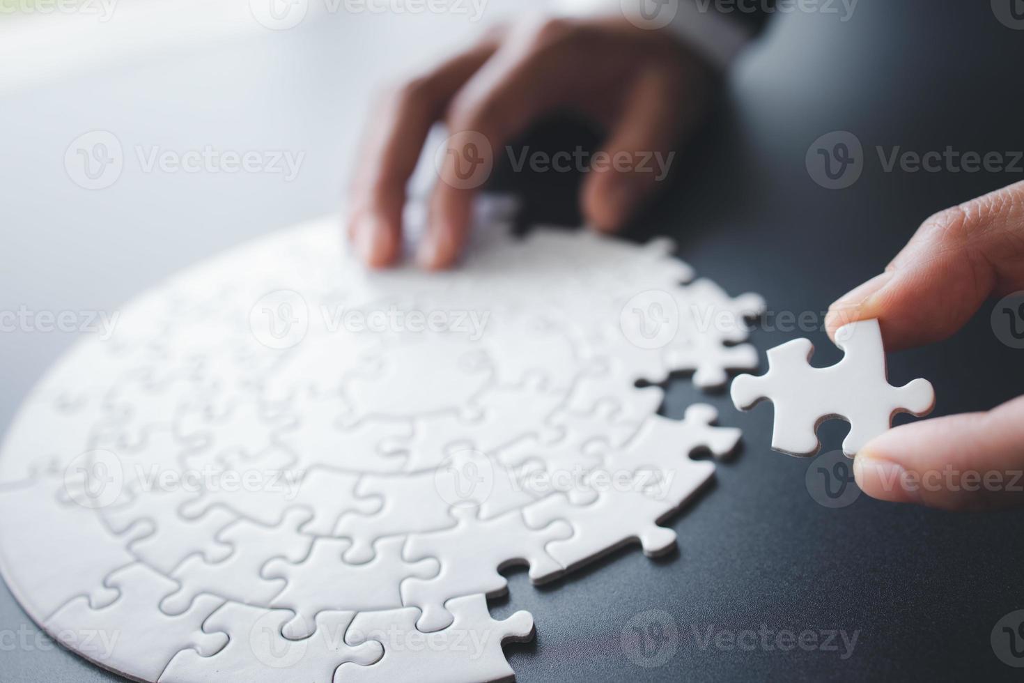 Hand putting piece of jigsaw puzzle. Team business success partnership or teamwork. photo