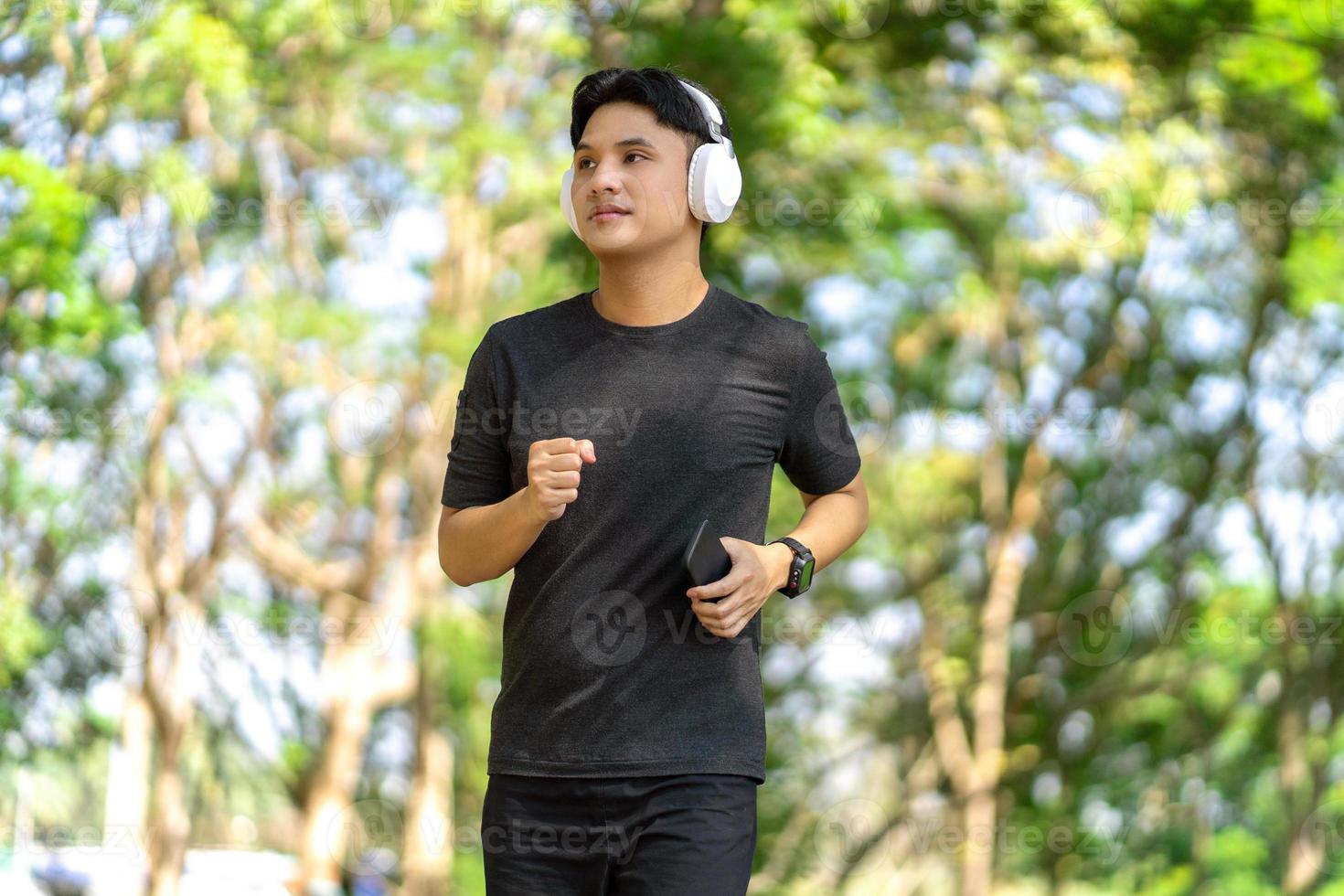 Healthy Asian man is jogging outdoor. Man exercising at outdoor park. Sport healthy running concept. photo