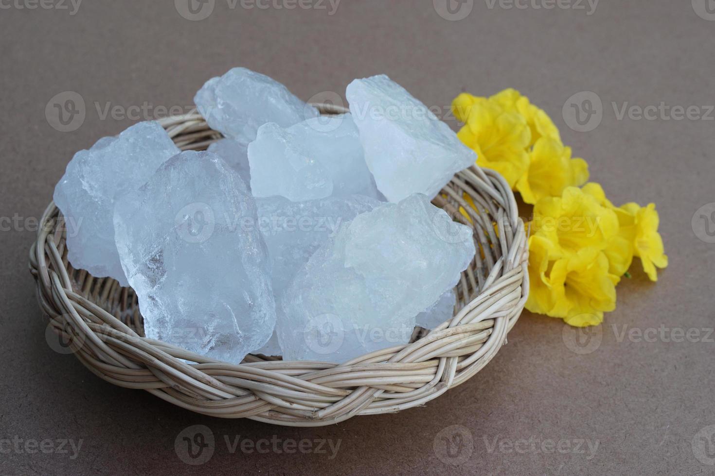 Crystal clear alum stones or Potassium alum on basket, decorated with flowers. Useful for beauty