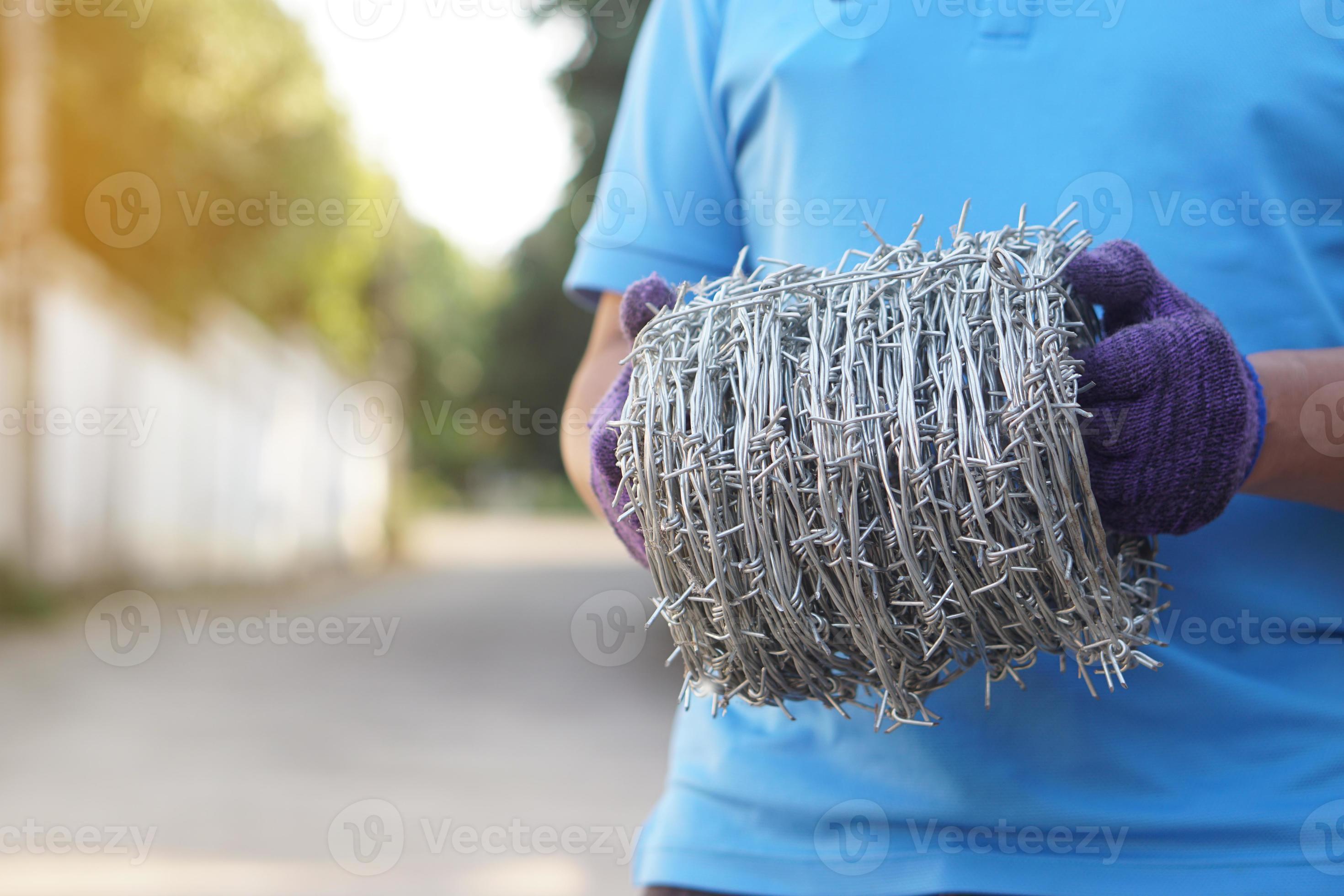 Closeup worker hand holds roll of barbed wire. Concept, construction