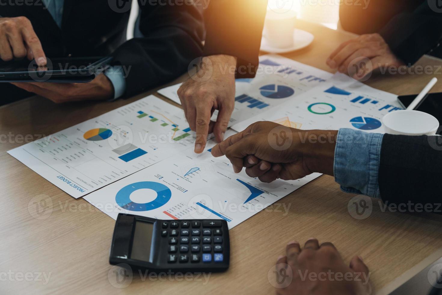Financial analysts analyze business financial reports on a digital tablet planning investment project during a discussion at a meeting of corporate showing the results of their successful teamwork. photo