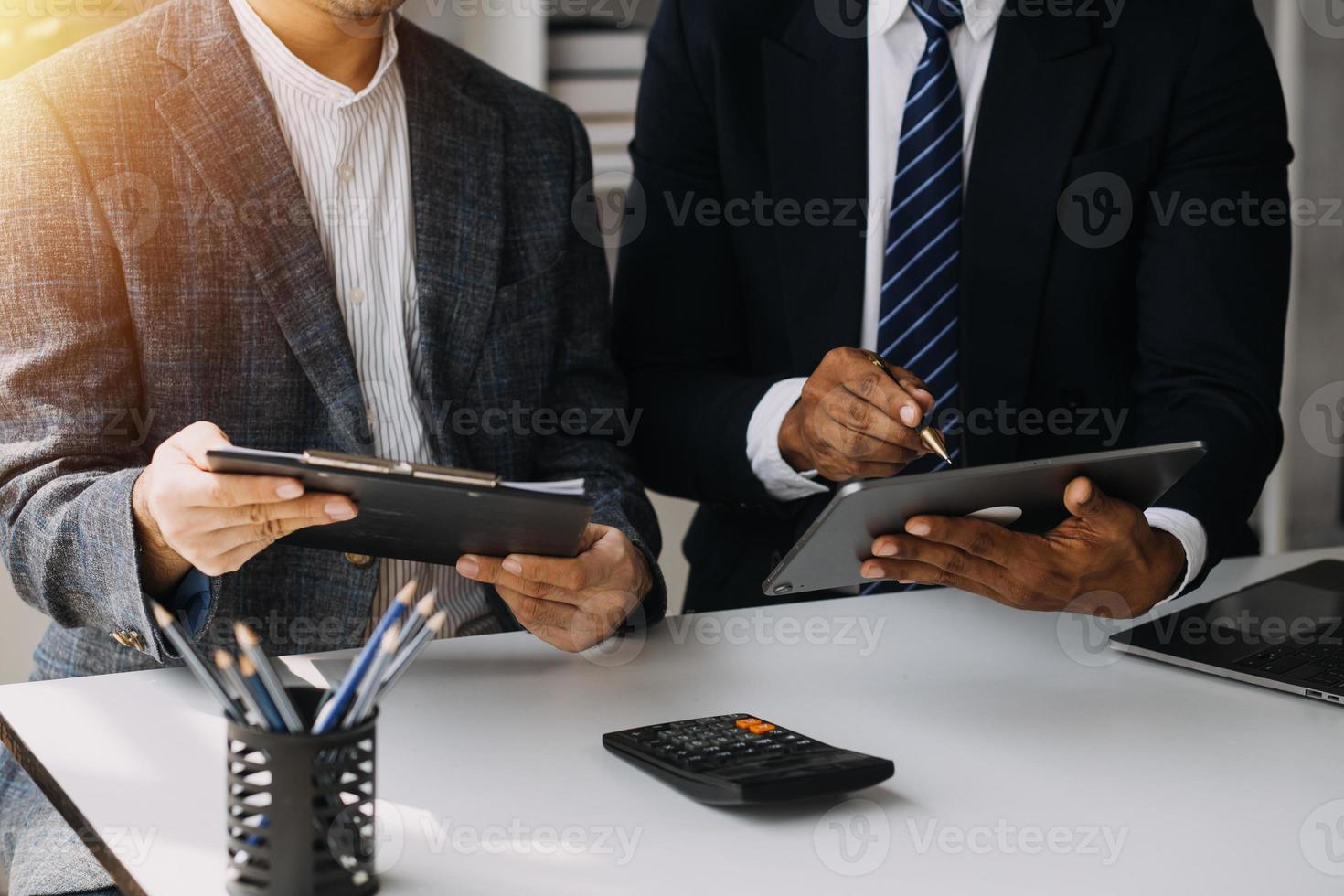 Financial analysts analyze business financial reports on a digital tablet planning investment project during a discussion at a meeting of corporate showing the results of their successful teamwork. photo