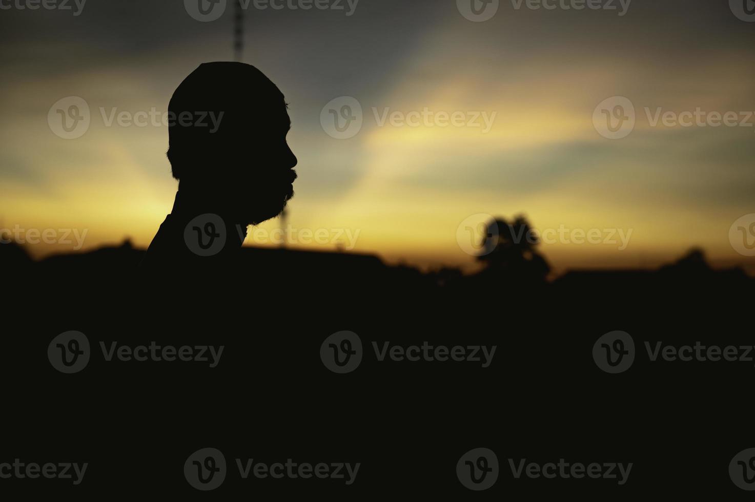 Silhouette Young asian muslim man praying on sunset,Ramadan festival concept photo