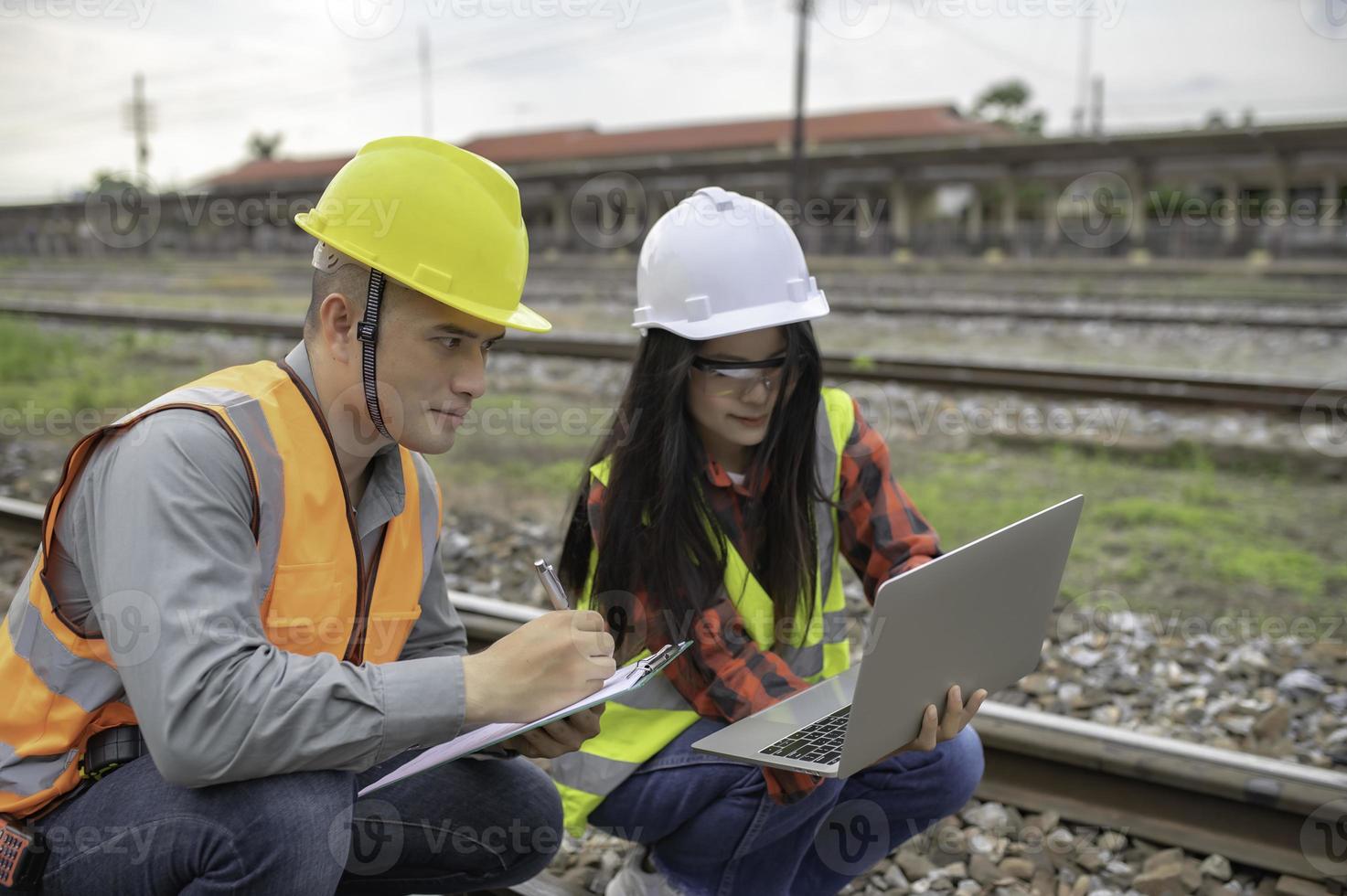 Two engineer working at train station,Work together happily,Help each other analyze the problem,Consult about development guidelines photo