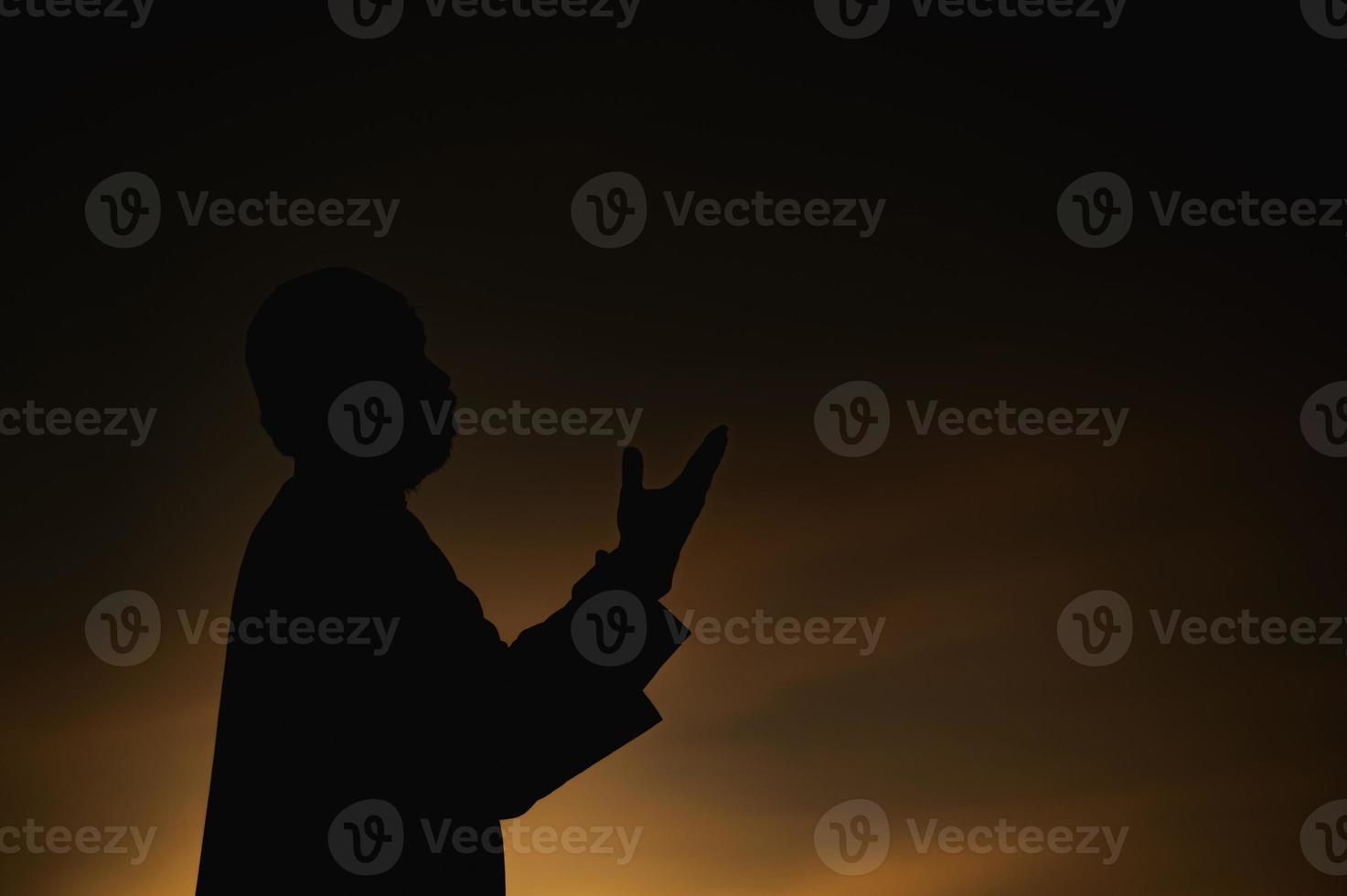 Silhouette Young asian muslim man praying on sunset,Ramadan festival concept photo