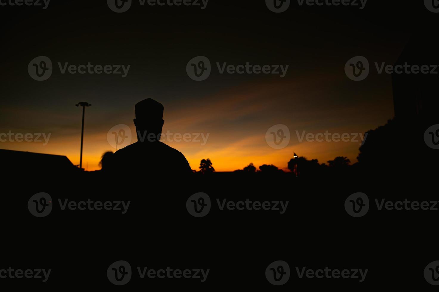 Silhouette Young asian muslim man praying on sunset,Ramadan festival concept photo