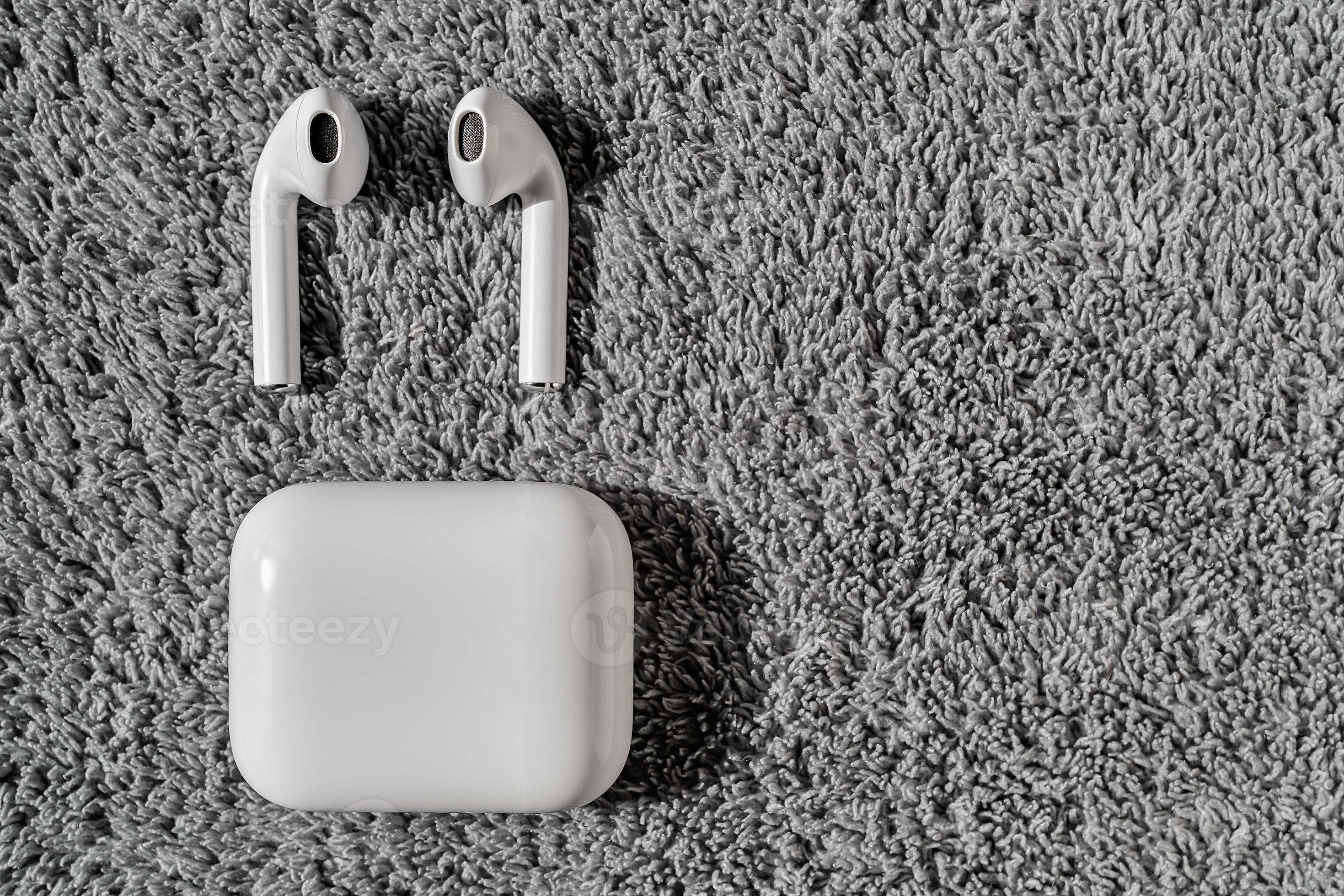 Top view on wireless white headphones on a gray velvet background 