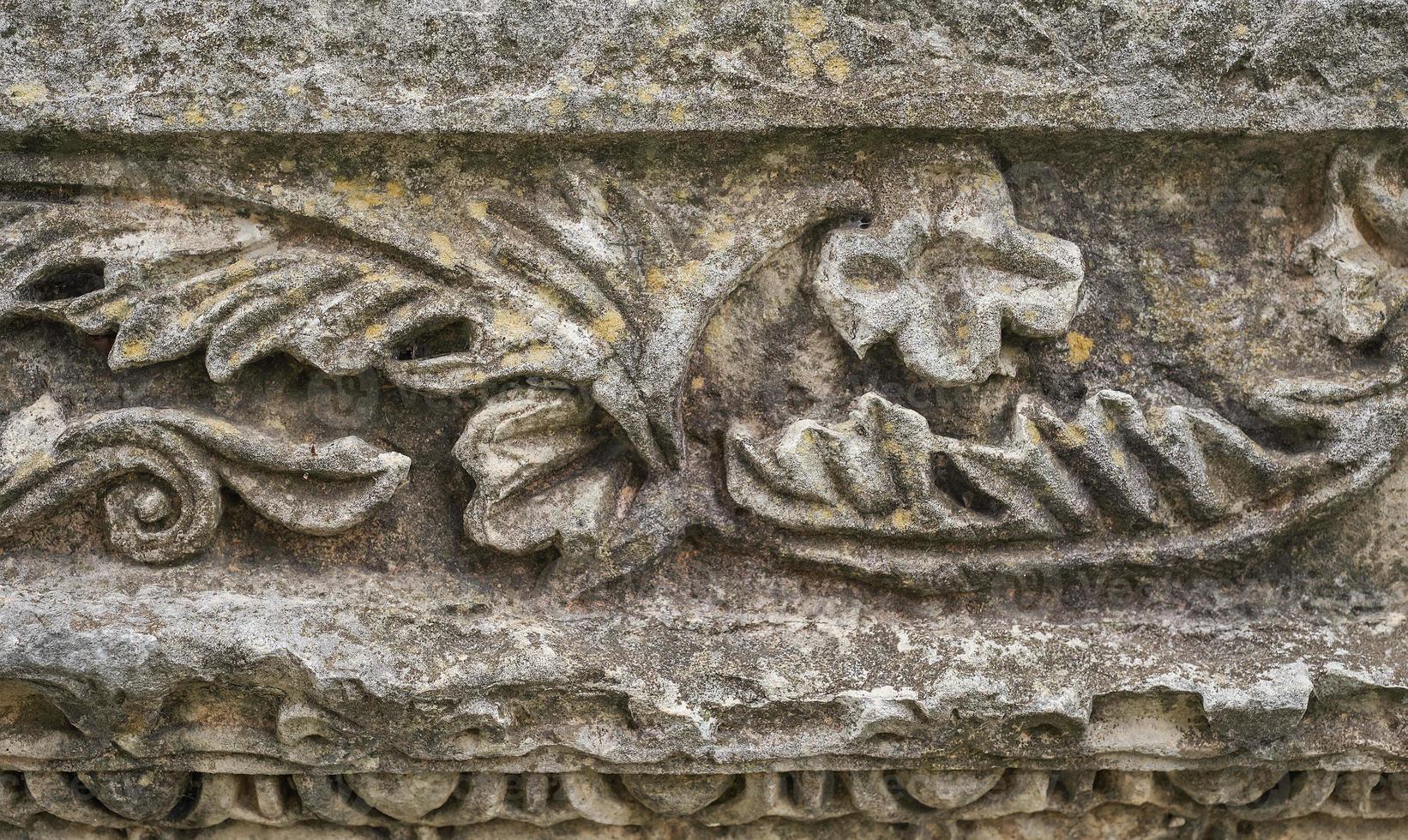 Details of carved stones on the top of the portico, beautiful stone carvings, history and heritage of ancient civilizations, details of a temple in the Aegean region of Turkey photo