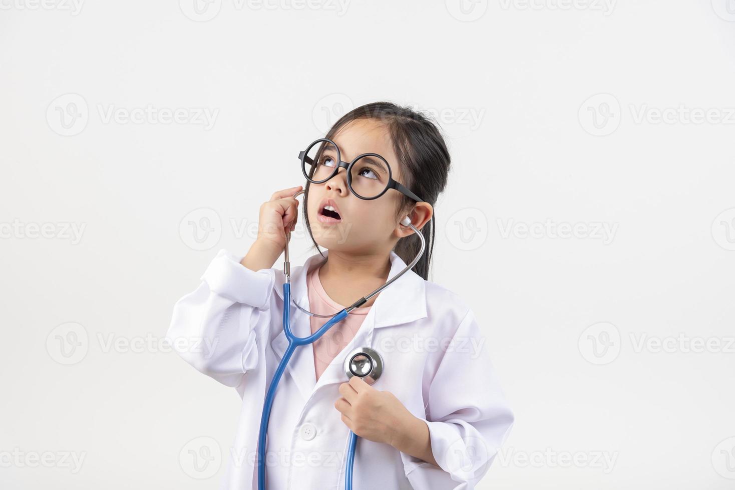 Asia little girl playing doctor isolated on white photo