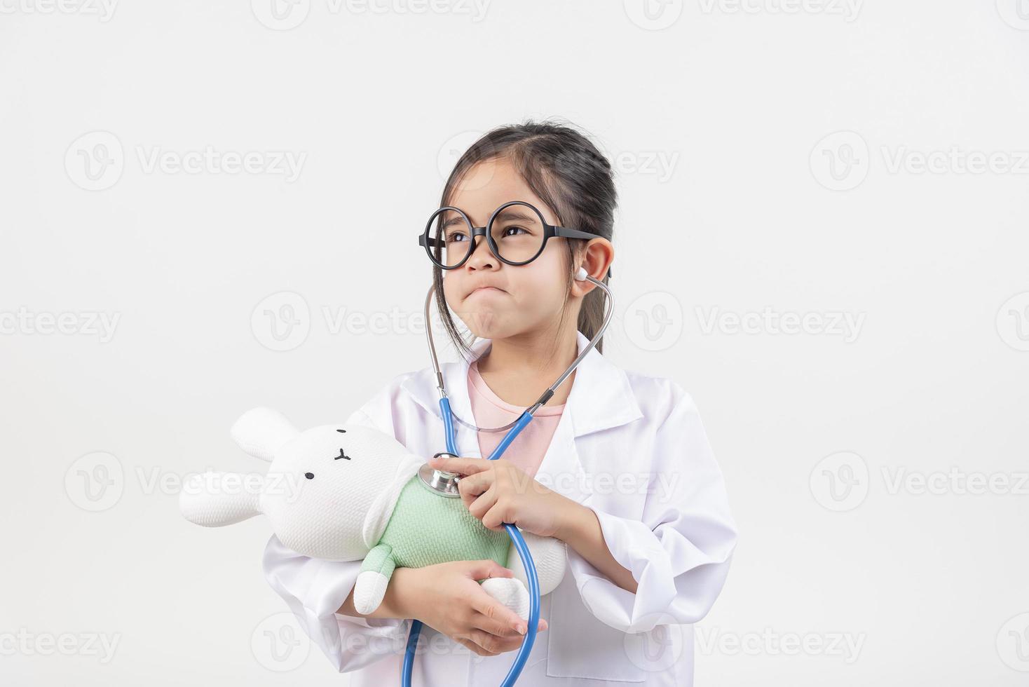 Asia little girl playing doctor isolated on white photo