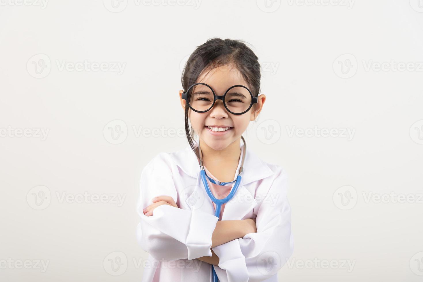 Asia pequeño niña jugando médico aislado en blanco foto