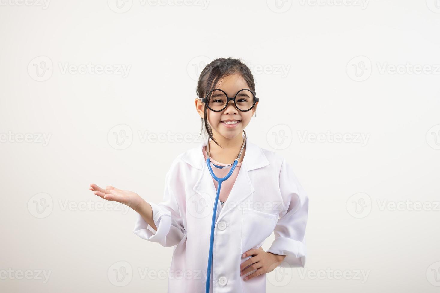 Asia pequeño niña jugando médico aislado en blanco foto