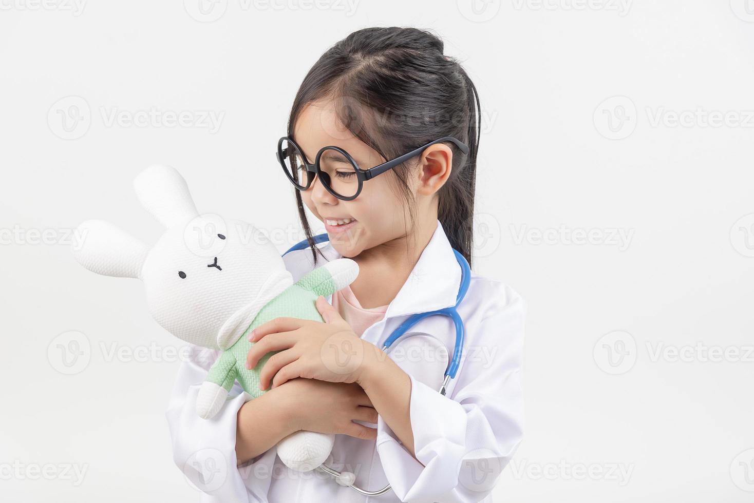 Asia little girl playing doctor isolated on white photo