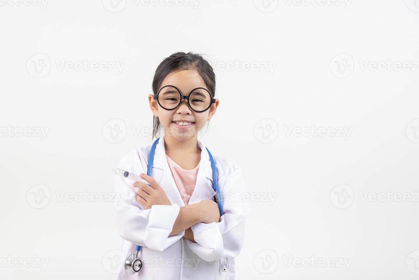 Asia pequeño niña jugando médico aislado en blanco foto