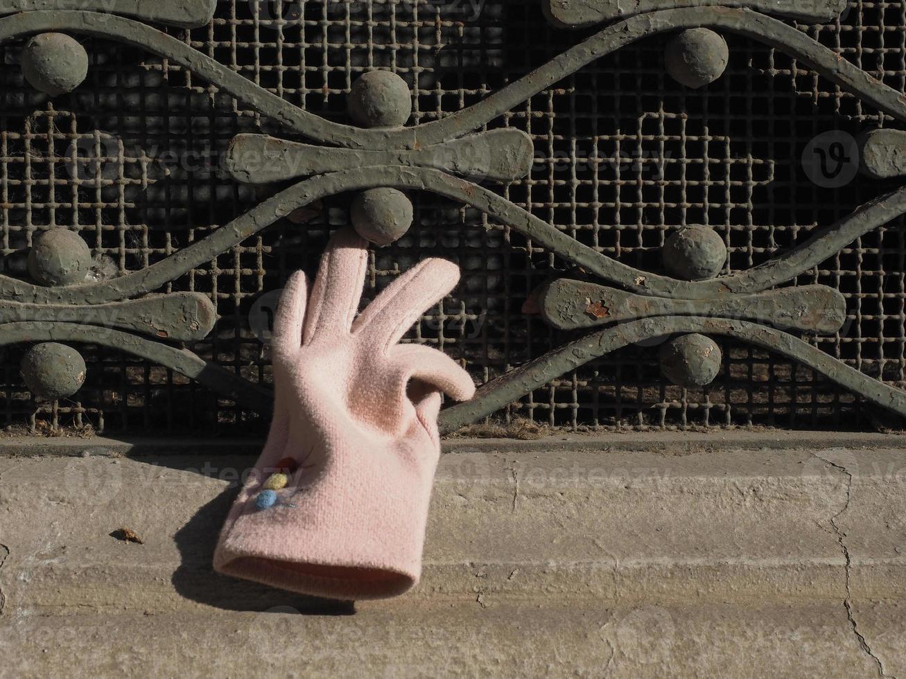 pink glove on window grate photo