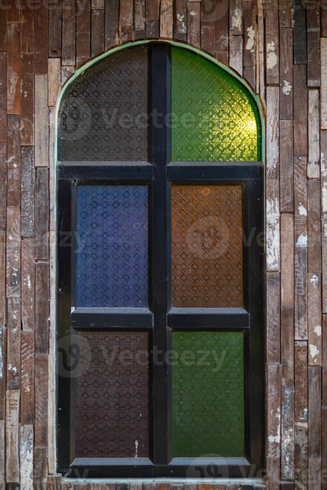 Retro-style wooden windows use stained glass to decorate the window niches for a colorful and classic look that makes the window interesting and eye-catching. photo