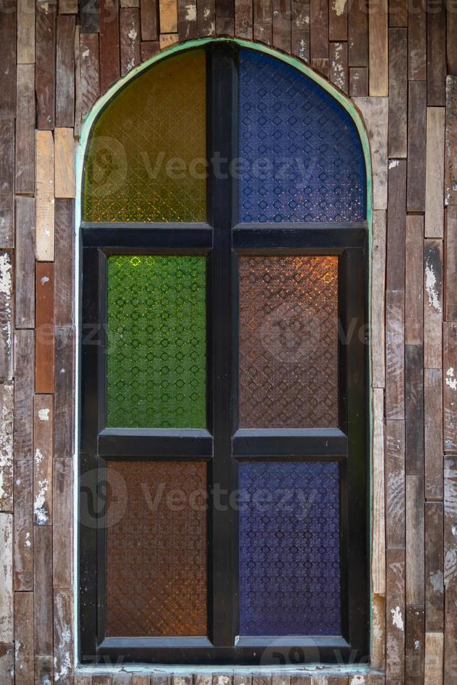 Retro-style wooden windows use stained glass to decorate the window niches for a colorful and classic look that makes the window interesting and eye-catching. photo