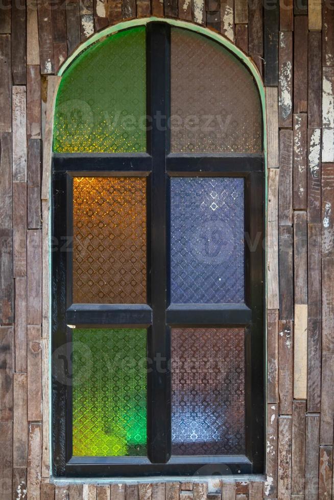 Retro-style wooden windows use stained glass to decorate the window niches for a colorful and classic look that makes the window interesting and eye-catching. photo