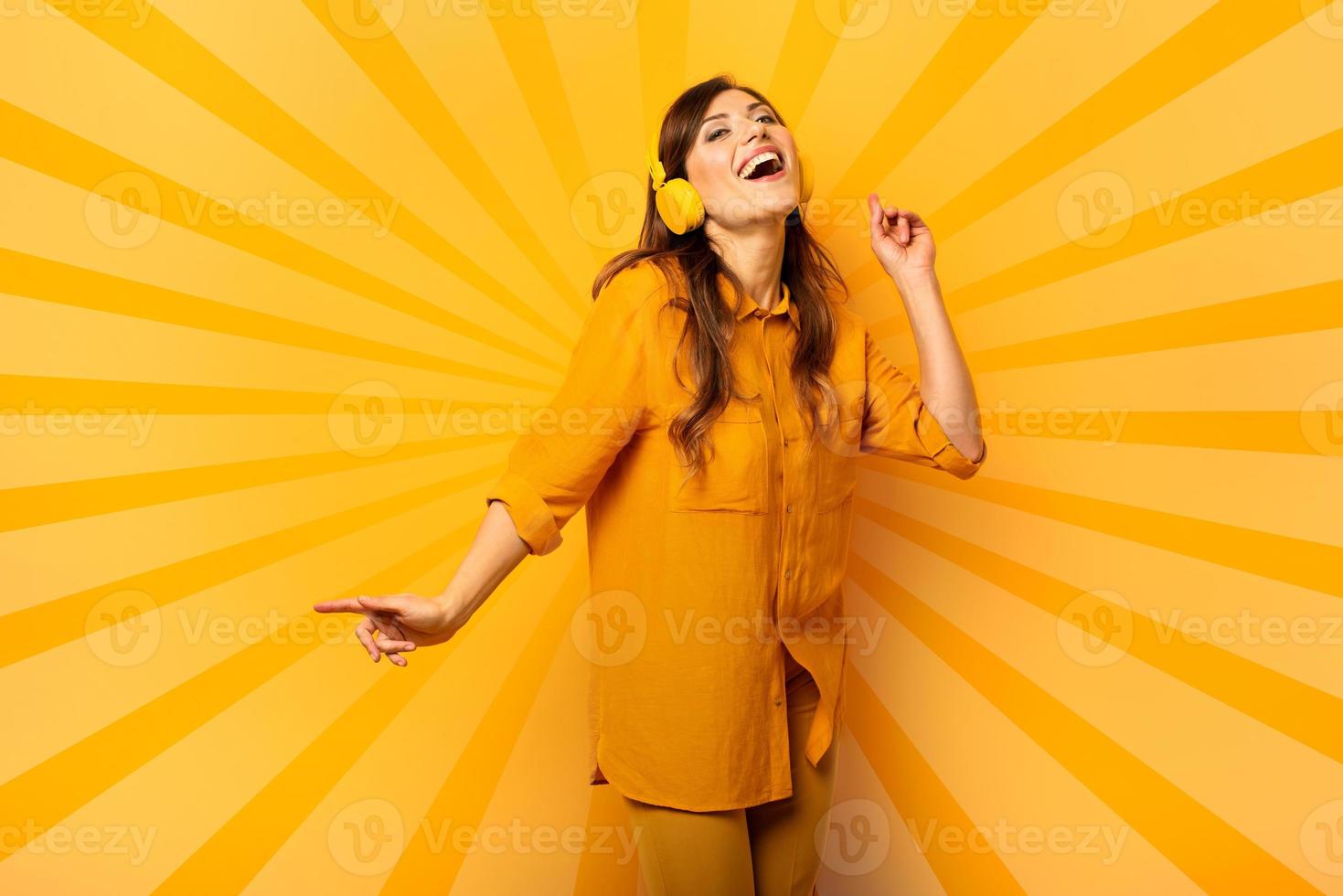 Girl with yellow headset listens to music and dances. emotional and energetic expression photo