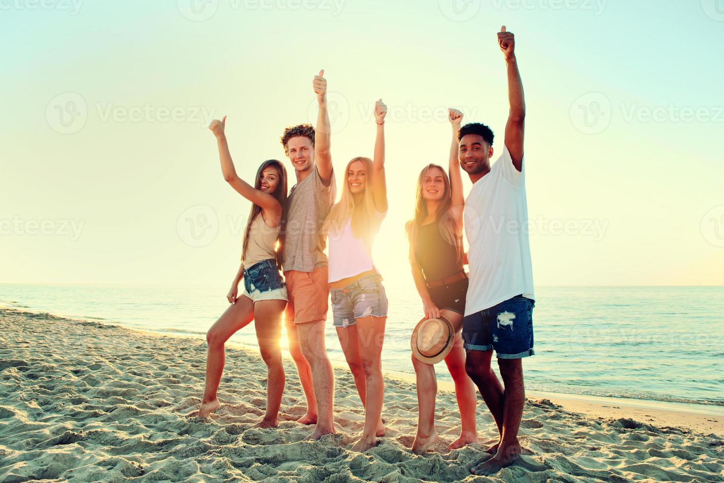 Group of friends having fun on the beach. Concept of summertime photo